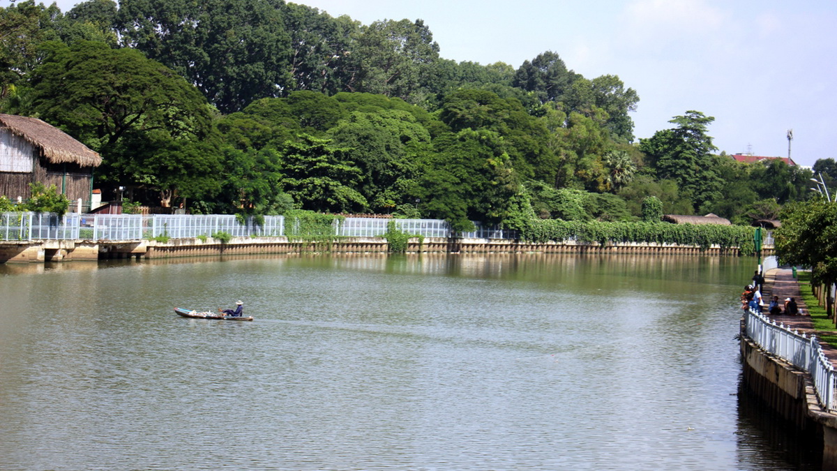 Bơi xuồng giăng lưới ngang kênh Nhiêu Lộc (đoạn dưới chân cầu Thị Nghè 2) đánh bắt cá - Ảnh: SƠN BÌNH
