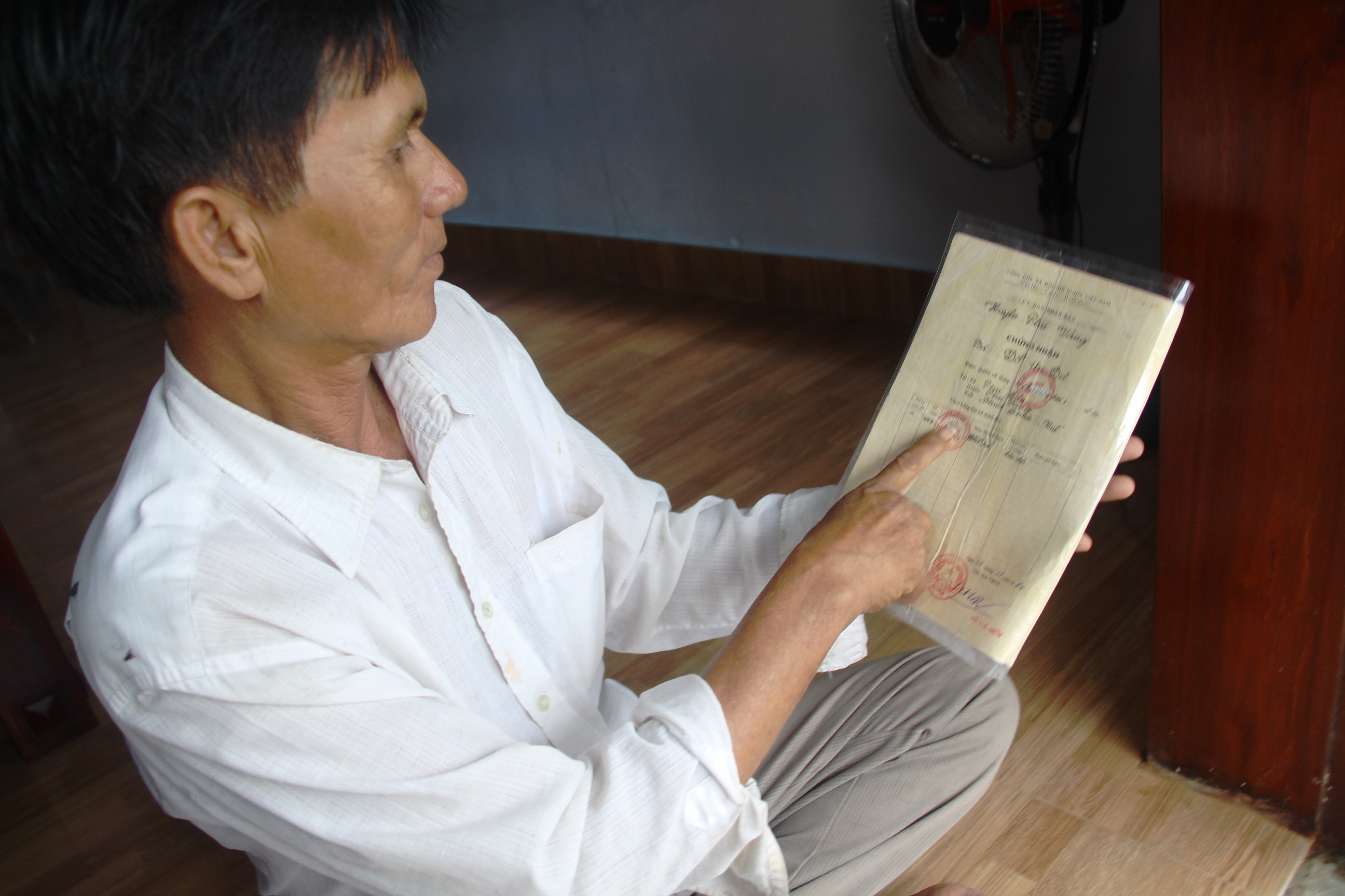 Ông Trần Tuất ở xã Phú Diên, huyện Phú Vang (Thừa Thiên - Huế) với “sổ đỏ” bị tẩy xóa, chỉnh sửa diện tích đất - Ảnh: NHẬT LINH