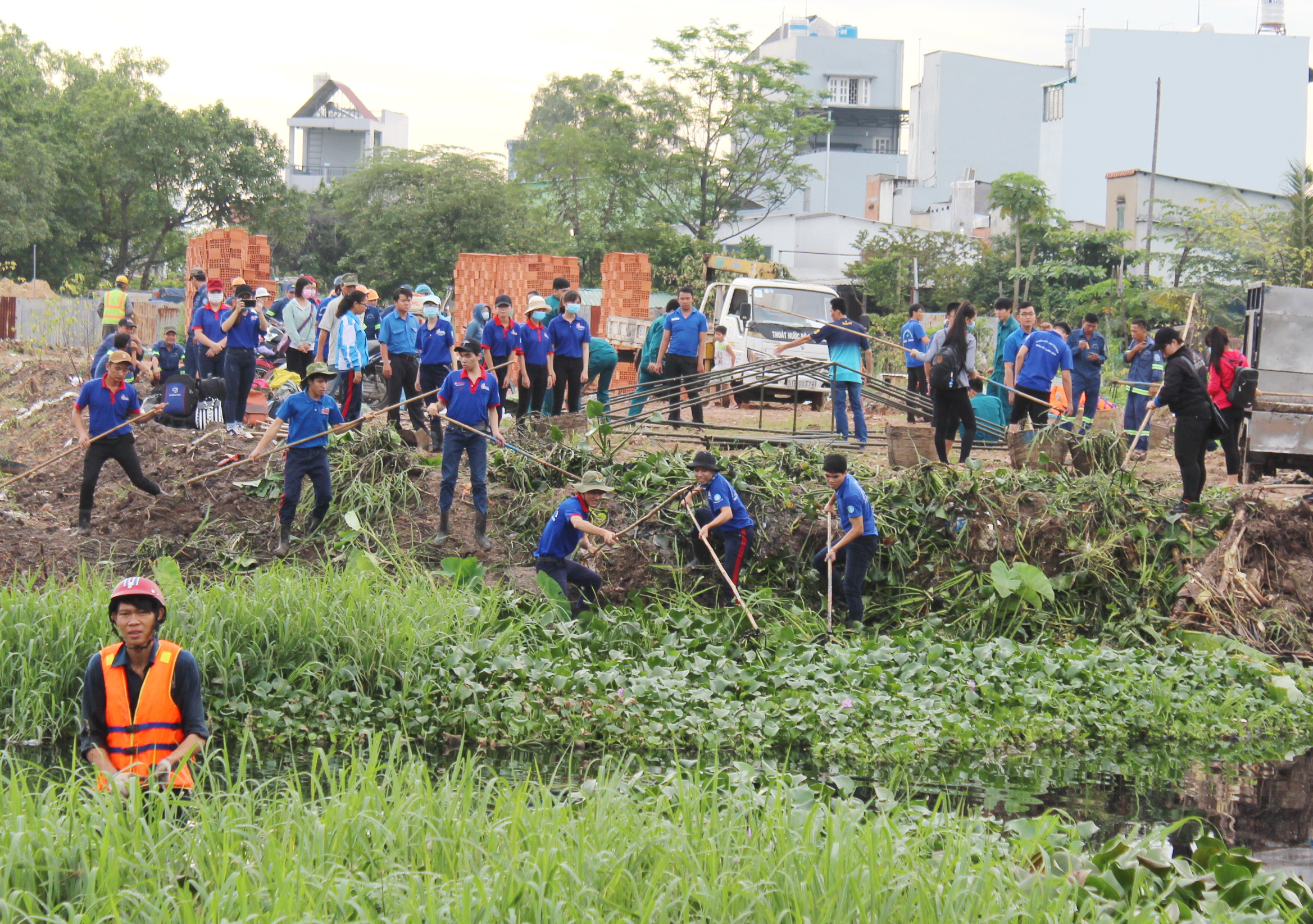 Các bạn trẻ tham gia khơi thông dòng chảy rạch Cụt tại Q.Gò Vấp (TP.HCM) để phòng chống muỗi, diệt lăng quăng - Ảnh: Q.L.