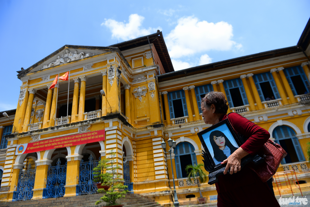 Người thân của nạn nhân tử vong trong vụ thảm sát ở Bình Phước mang di ảnh của cháu mình đến tòa án trong vụ xét xử phúc thẩm bị cáo Nguyễn Hải Dương - Ảnh: HỮU KHOA