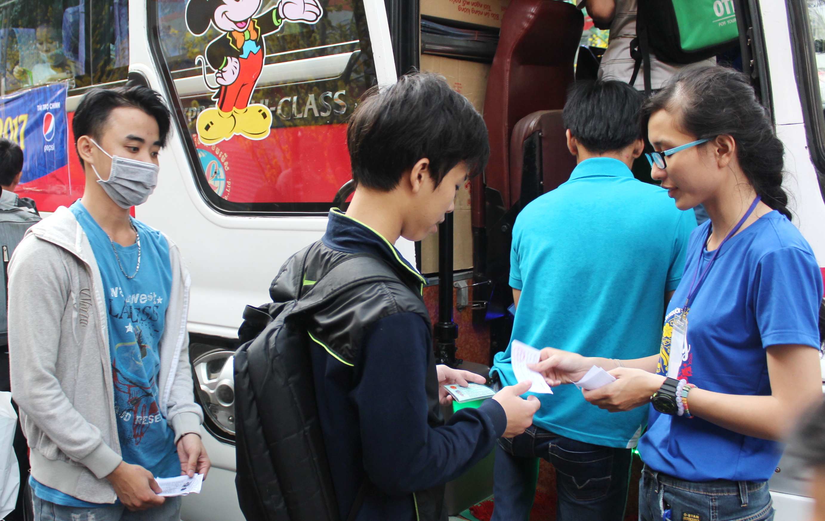 Tình nguyện viên giúp kiểm tra vé của sinh viên trước khi lên xe - Ảnh: Q.L.
