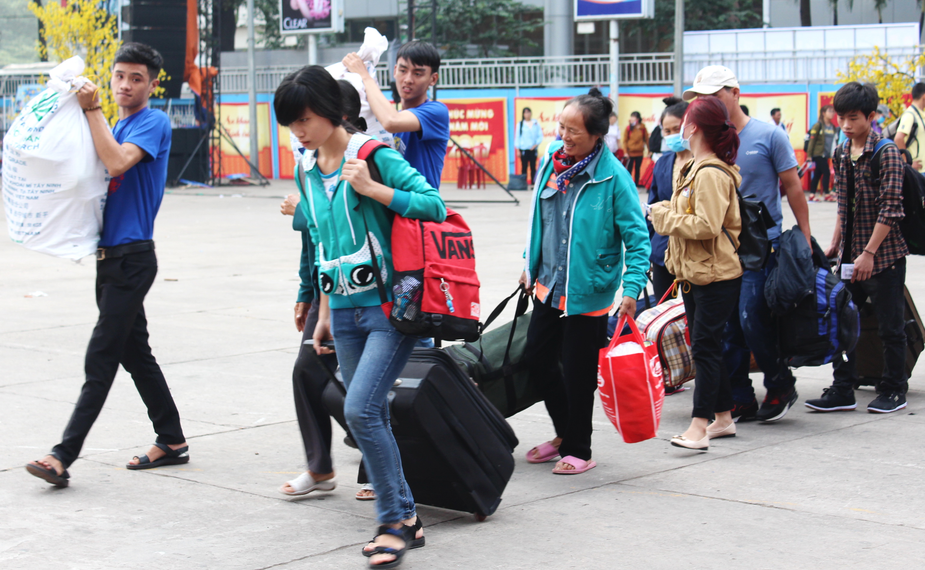 Nhiều bạn tình nguyện viên tham gia mang hành lý ra xe cho các cô chú lớn tuổi - Ảnh: Q.L.