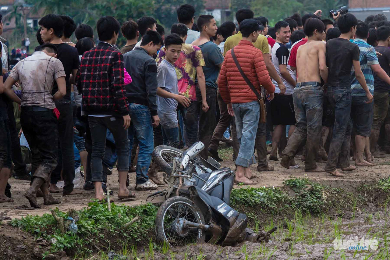 Một chiếc xe máy bị đám đông xô đổ xuống ruộng - Ảnh: NGUYỄN KHÁNH