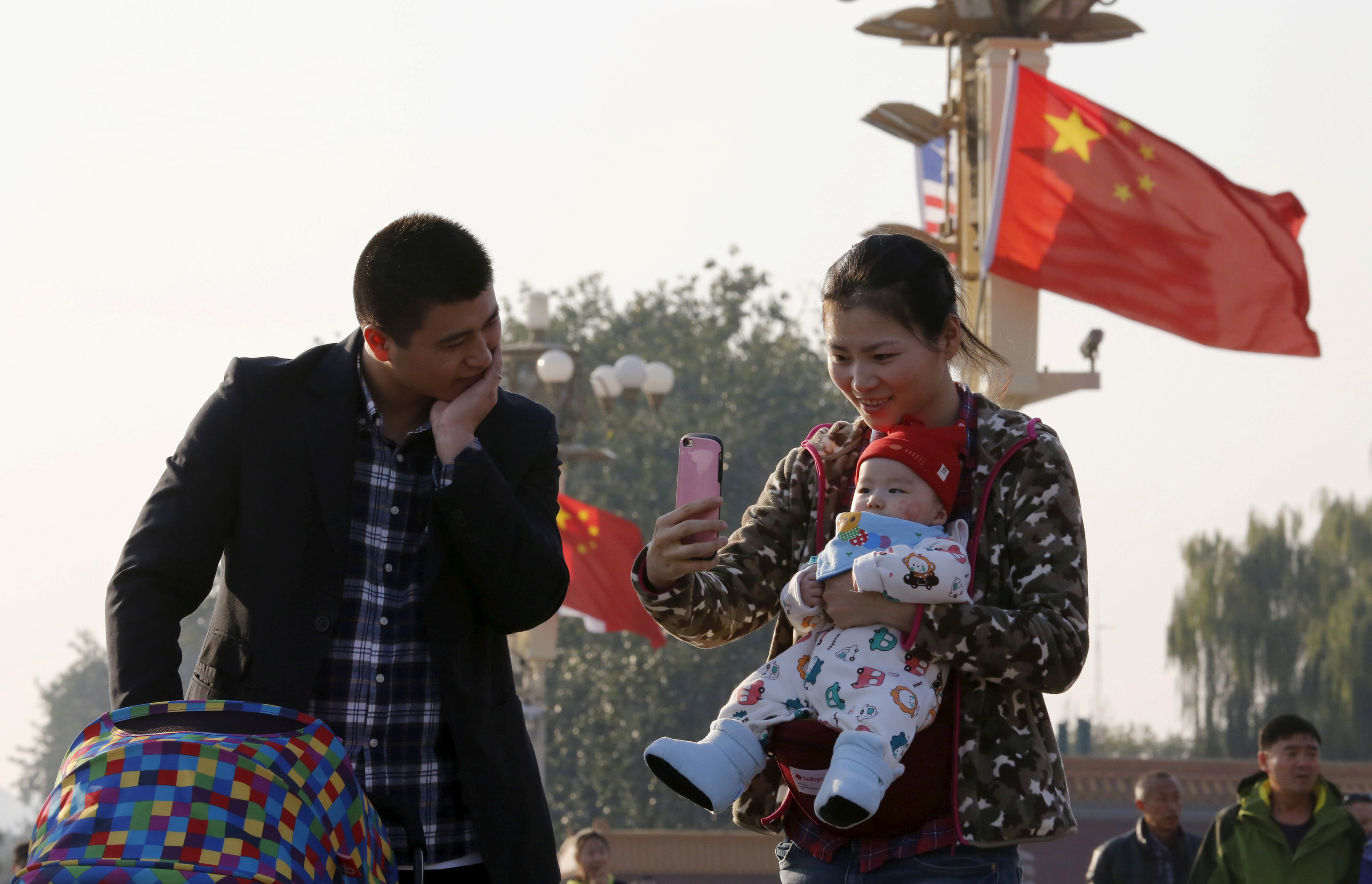 Một cặp vợ chồng Trung Quốc chụp hình với đứa con ở cổng Thiên An Môn, thành phố Bắc Kinh - ảnh: Reuters
