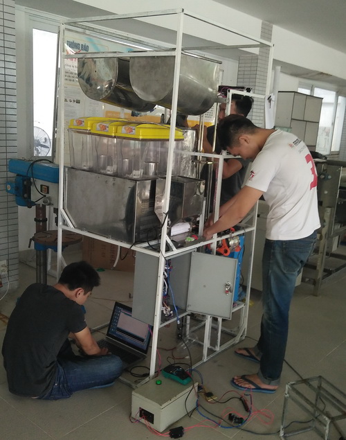 Sinh viên đang kiểm tra máy bán trà sữa tự động - Ảnh: Hồng Nhung