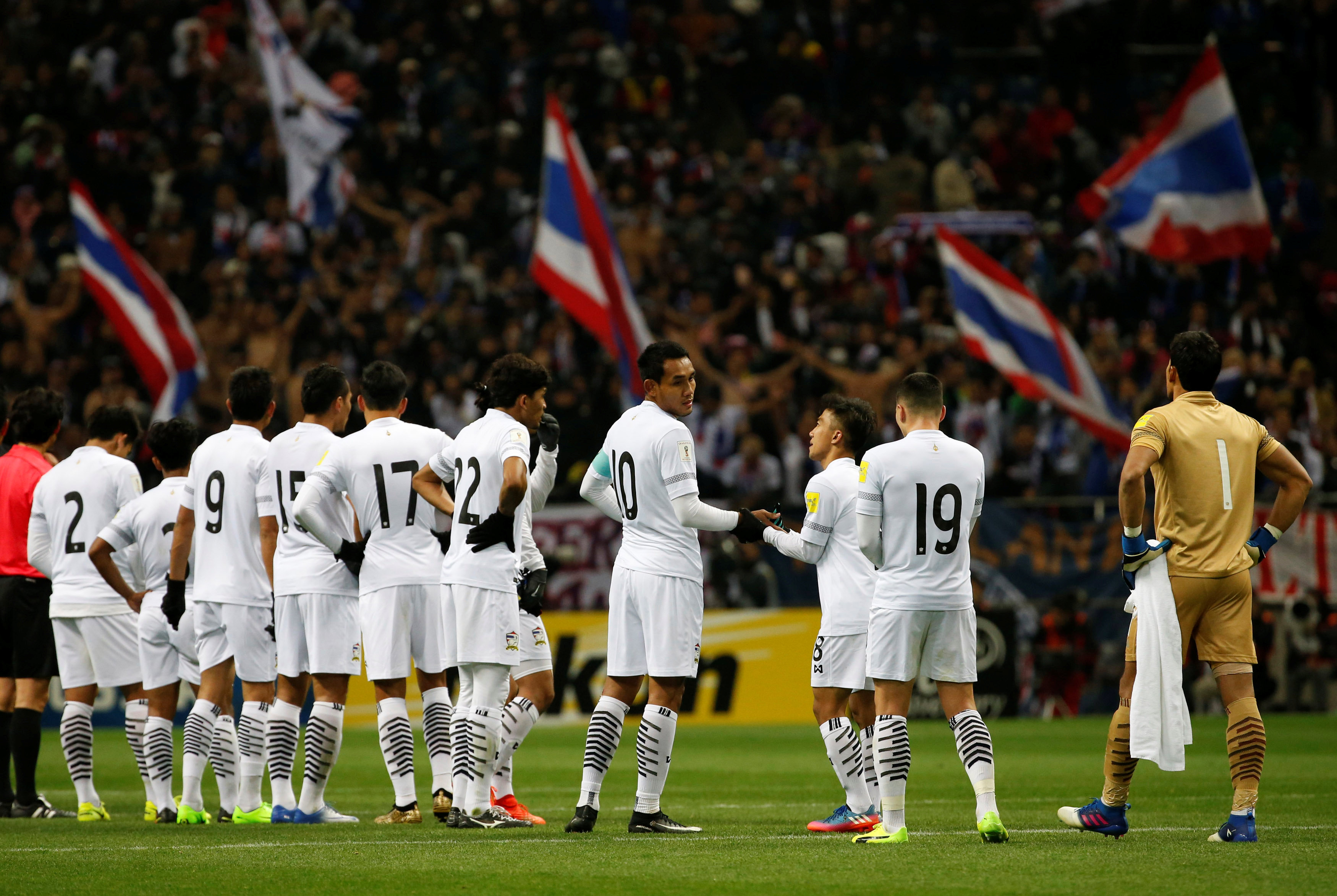 Các cầu thủ Thái Lan xếp hàng xin lỗi người hâm mộ sau trận thua thảm Nhật Bản. Ảnh: REUTERS
