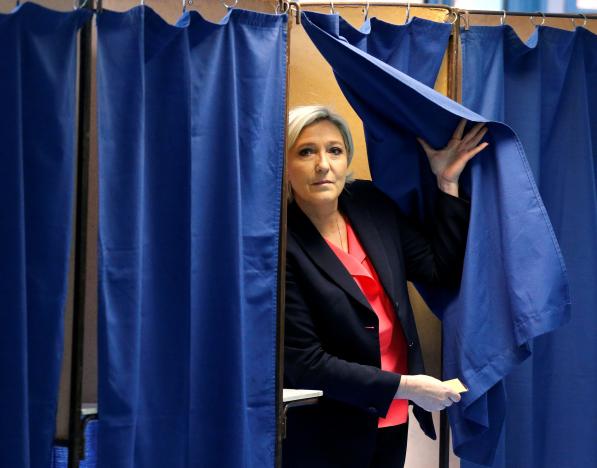 Ứng viên Đảng Mặt trận Dân tộc (FN) tại một điểm bỏ phiếu ở Henin-Beumont ngày 7-5 - Ảnh: Reuters