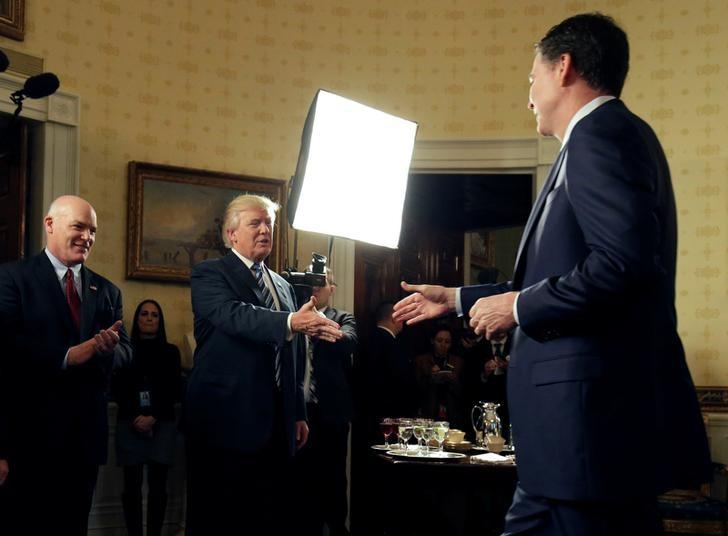 Tổng thống Mỹ Donald Trump (giữa) bắt tay ông James Comey - Ảnh: Reuters