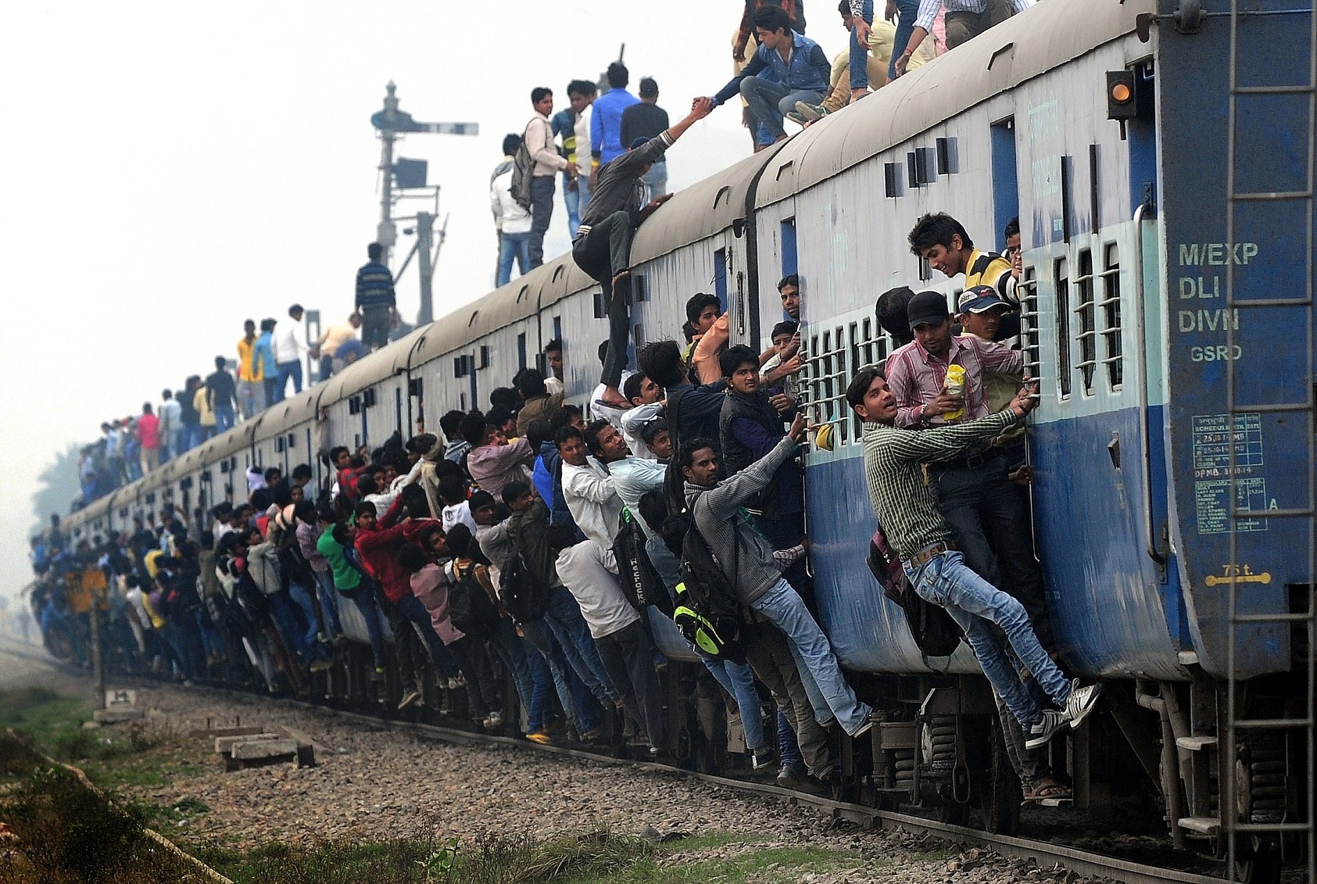 Không còn chỗ trống nào trên đoàn tàu rời ga ở ngoại ô New Delhi, Ấn Độ - Ảnh: AFP