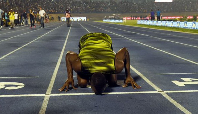 Bolt hôn xuống đường chạy tại Kingston ở giải đấu cuối cùng trong sự nghiệp trên sân nhà-Ảnh: BBC