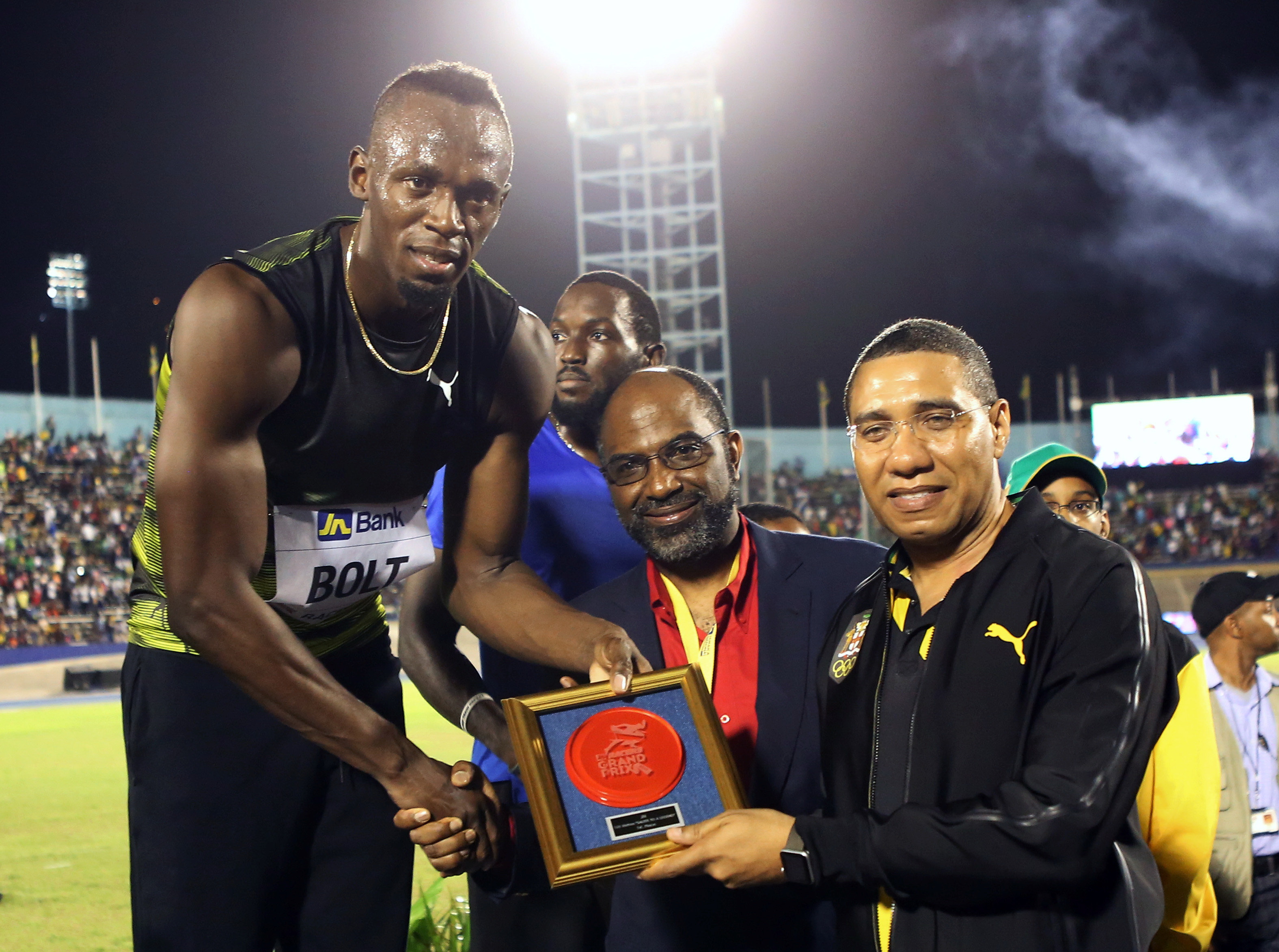 Thủ tướng Jamaica Andrew Holness (bìa phải) vinh danh Bolt trong ngày chia tay-Ảnh: Reuters