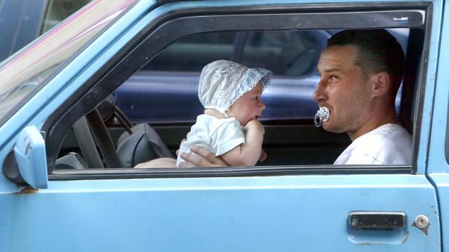 Một đứa trẻ đi xe cùng cha - Ảnh tư liệu: AFP