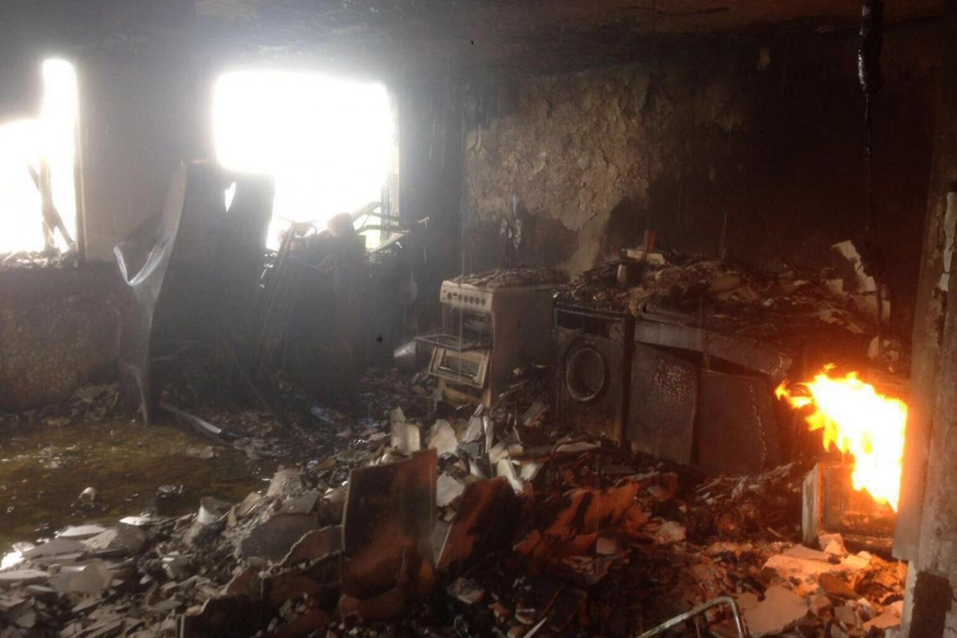 Khung cảnh gian bếp và những chiếc máy giặt bị thiêu rụi tại một căn hộ thuộc tòa nhà Grenfell bị cháy ở London - Ảnh: Evening Standard