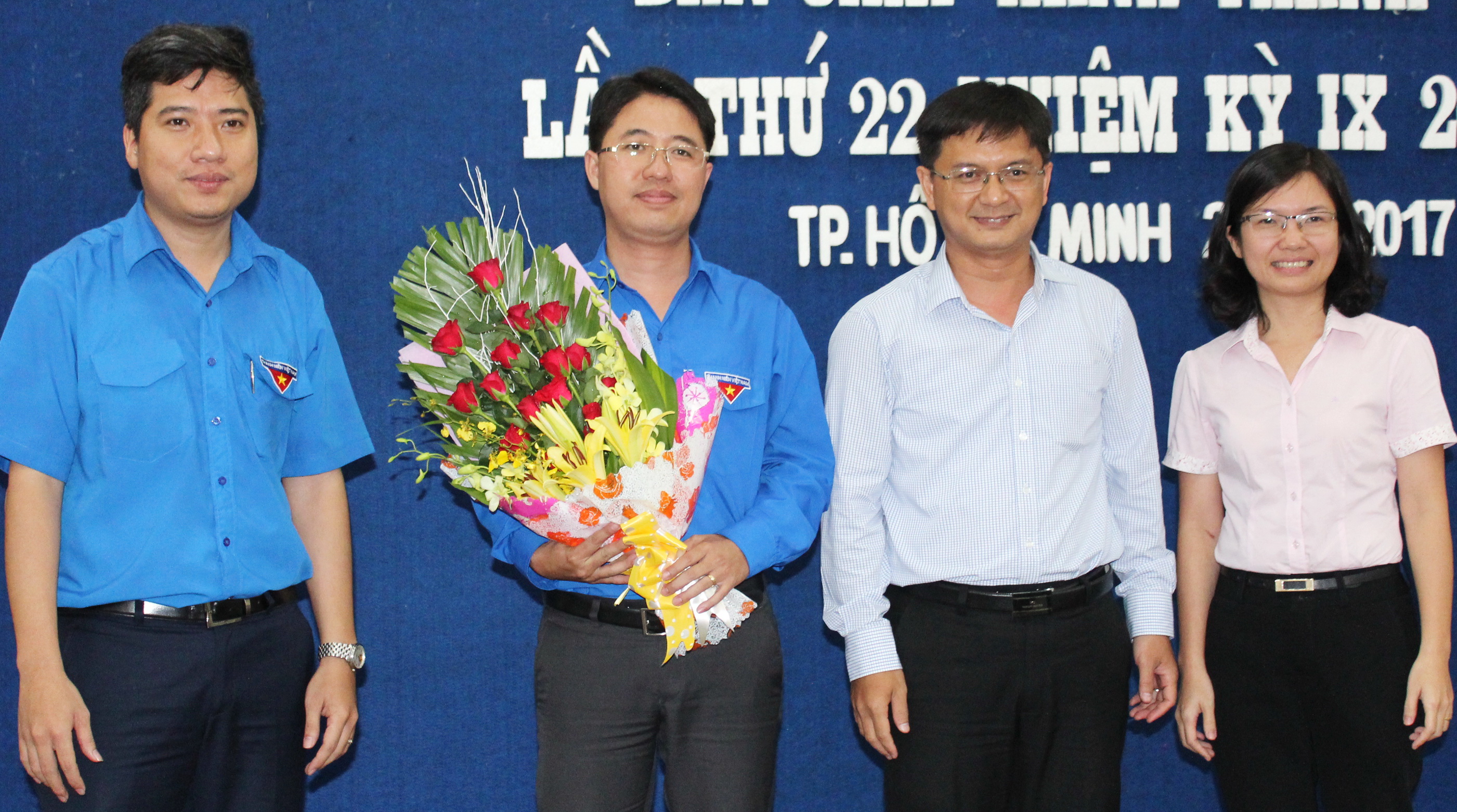 Tân Bí thư Thành đoàn TP.HCM Phạm Hồng Sơn (thứ hai từ trái qua) nhận hoa chúc mừng của thường trực Thành đoàn - Ảnh: Q.Linh