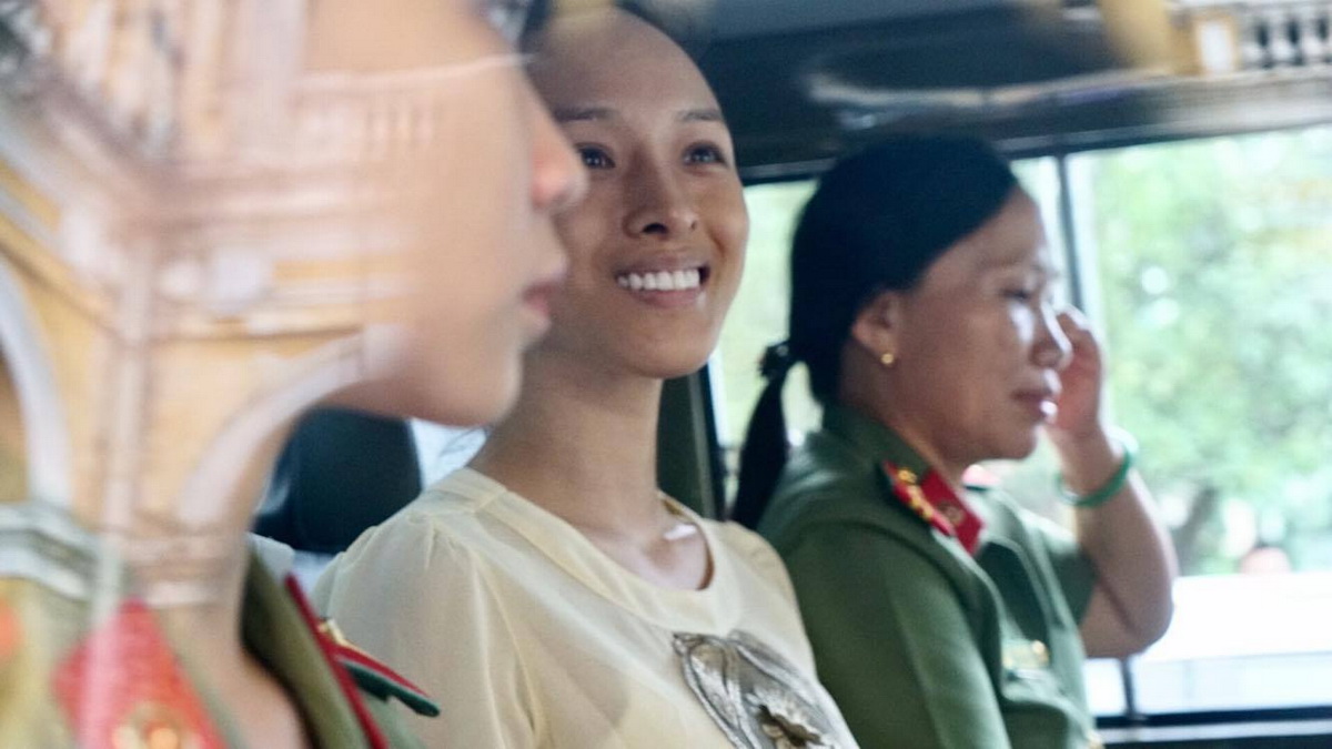 Phương Nga cười tươi với người thân khi lên xe thùng về lại trại tạm giam - Ảnh: Thuận Thắng