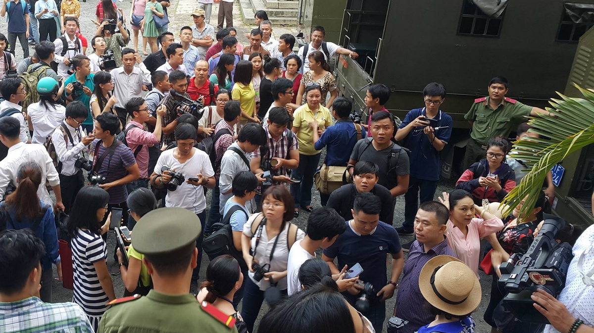 Đông đảo phóng viên báo chí vây quanh xe chở Phương Nga và Thùy Dung sau khi kết thúc phiên tòa - Ảnh: Hữu Khoa