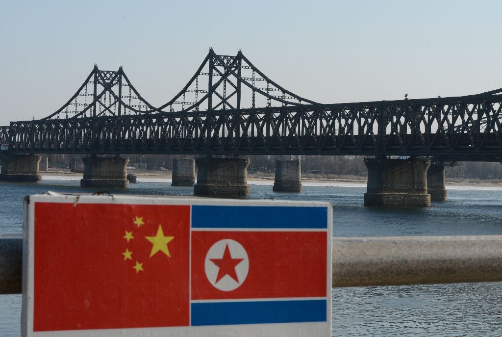 Lá cờ Trung Quốc (trái) bên cạnh cờ Triều Tiên tại cây cầu hữu nghị Trung -Triều Dandong - Ảnh: AFP