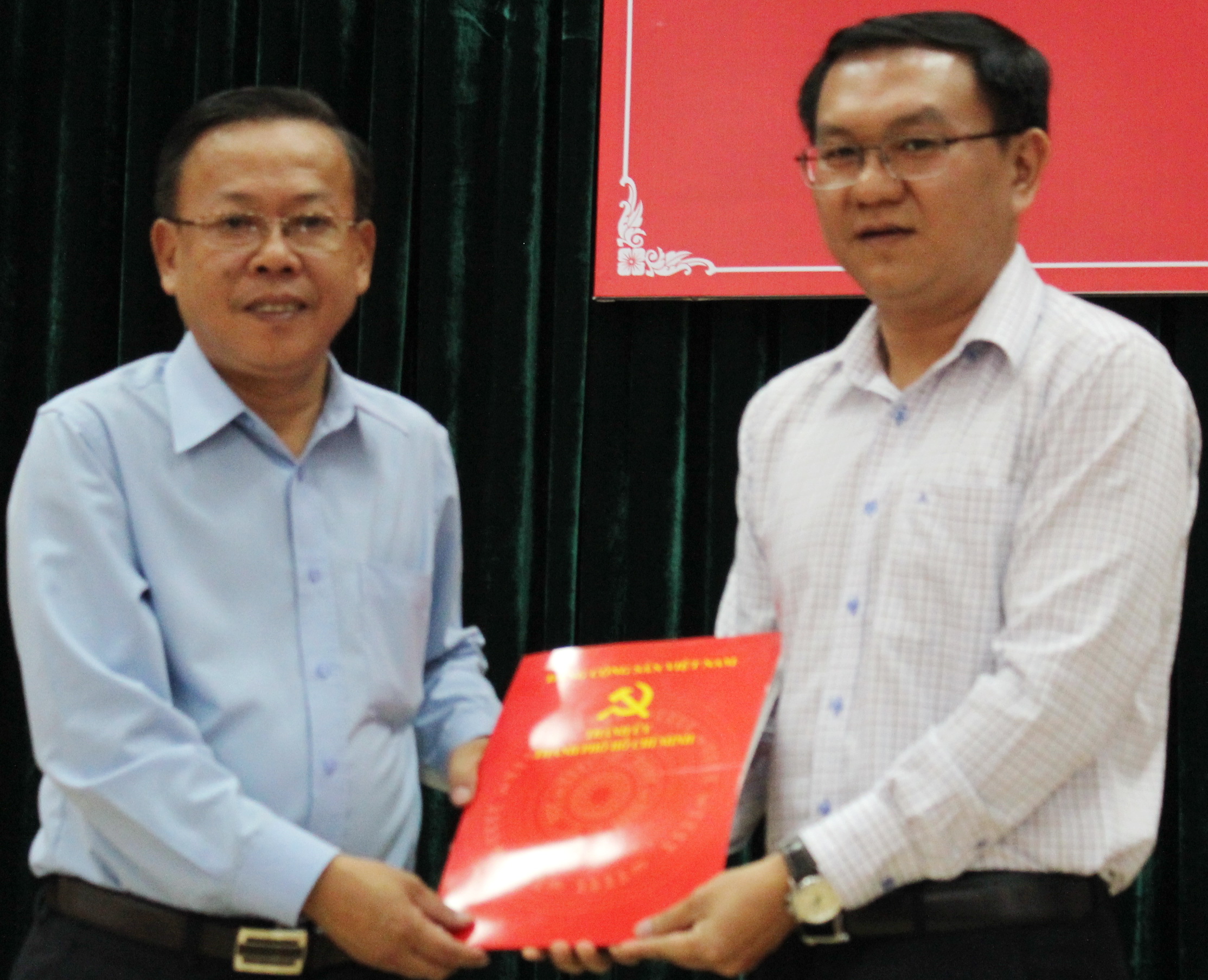 Trưởng ban tổ chức Thành ủy TP.HCM Nguyễn Hữu Hiệp trao quyết định điều động cho anh Lâm Đình Thắng (phải) - Ảnh: Q.L.