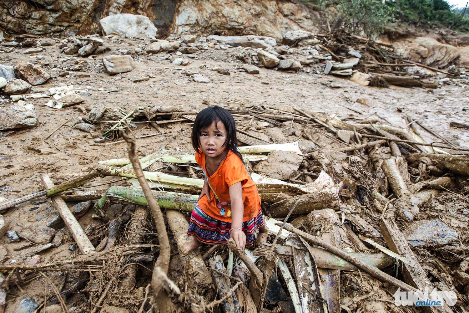 Cô bé Mùa Thị Nhung 4 tuổi đang cùng gia đình tìm kiếm những gì sót lại sau khi ngôi nhà bị nước lũ cuốn trôi - Ảnh: NGUYỄN KHÁNH