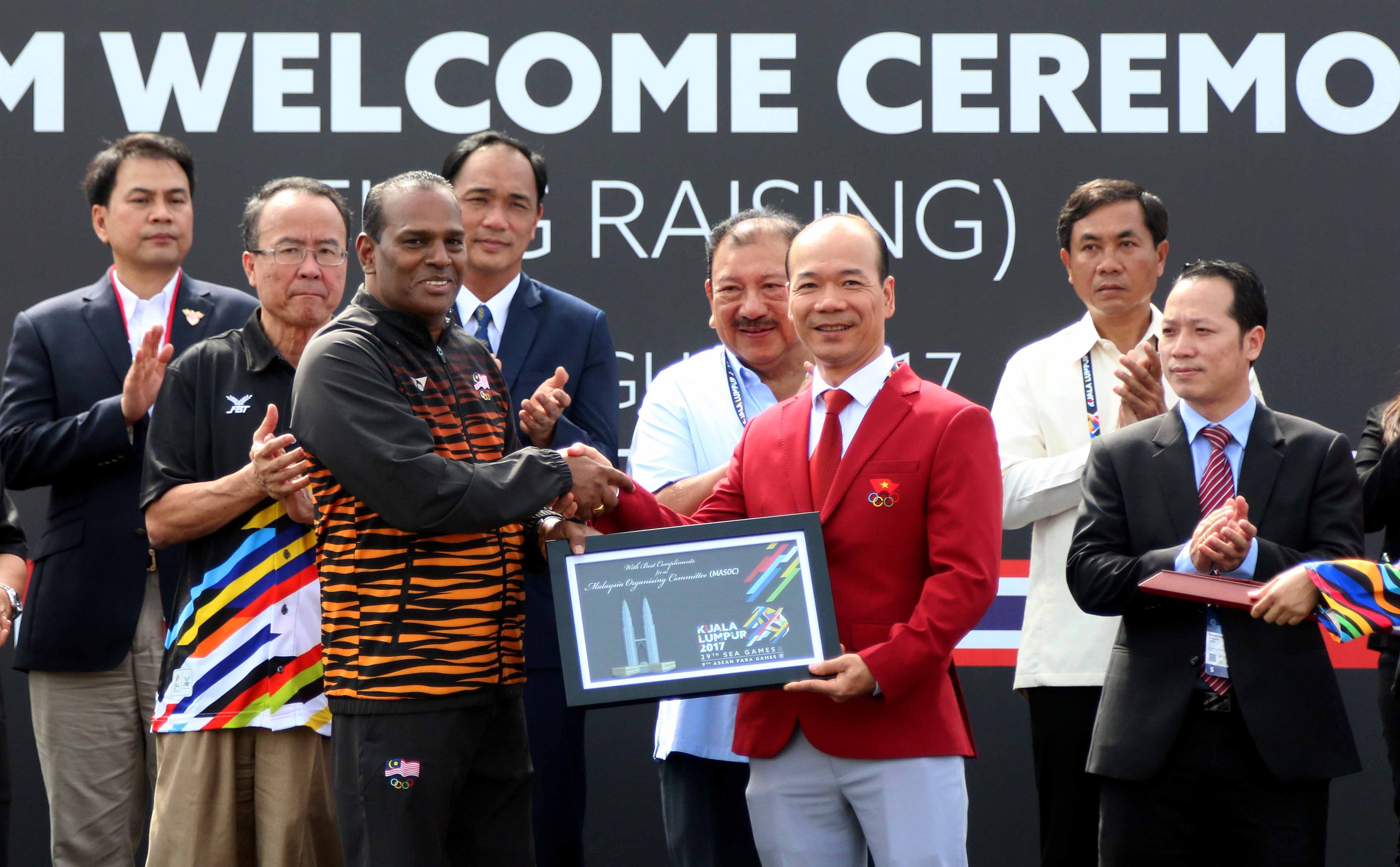 Phó trưởng đoàn thể thao VN Hoàng Quốc Vinh nhận quà tặng lưu niệm từ chủ nhà Malaysia. Ảnh: N.K