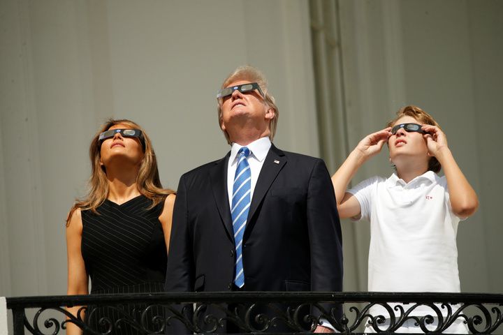 Tổng thống Trump cùng vợ Melania và con trai Barron quan sát nhật thực bằng kính chuyên dụng - Ảnh: Reuters
