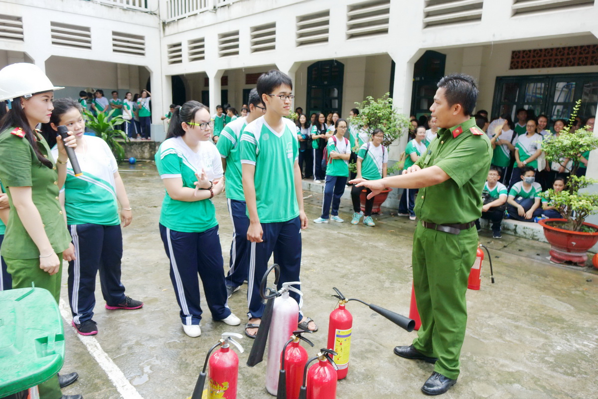 Cảnh sát PCCC hướng dẫn học sinh cách sử dụng bình chữa cháy trước khi thực hành - Ảnh: NHƯ HÙNG