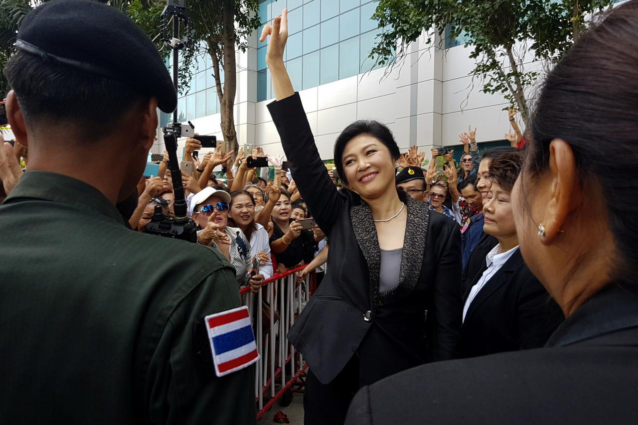 Cựu thủ tướng Thái Lan Yingluck Shinawatra chào người ủng hộ sau khi bước ra khỏi Tòa án Tối cao tại Bangkok ngày 1-8 - Ảnh: Reuters