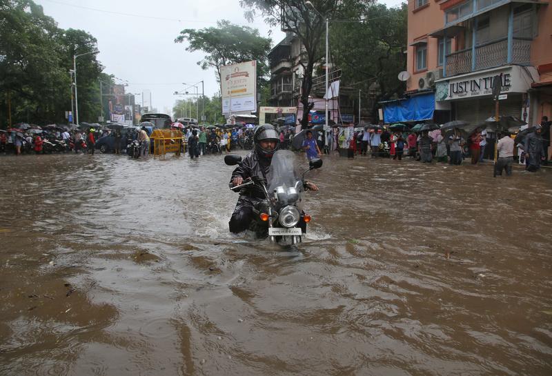 Người dân Mumbai lội nước về nhà - Ảnh: Reuters