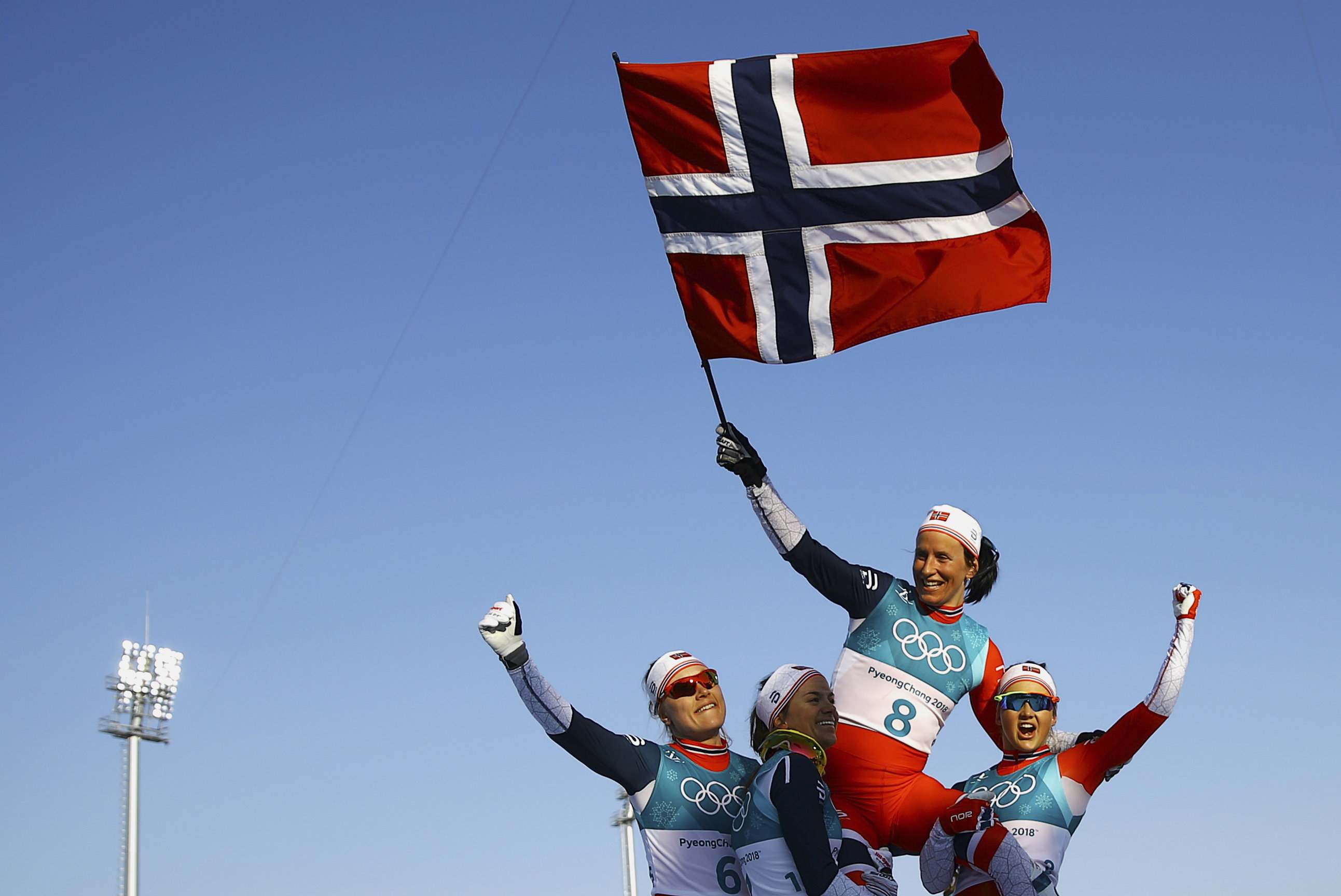 Marit Bjorgen được các đồng đội công kênh sau khi giành tấm HCV cuối cùng cho Na Uy. Ảnh: REUTERS
