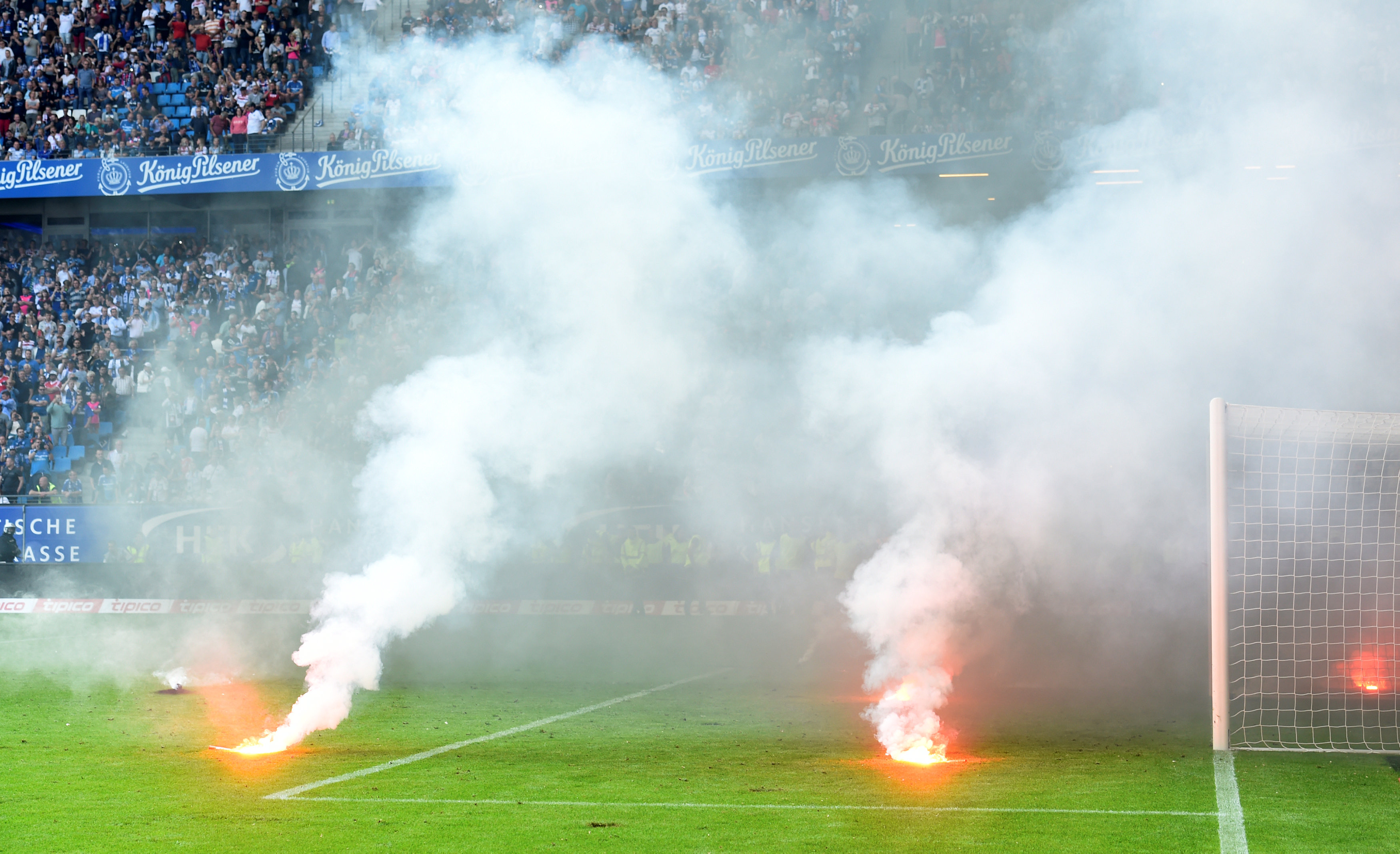 Các CĐV Hamburger ném pháo sáng xuống sân, khiến trận đấu bị hoãn ở những phút đấu thêm giờ. Ảnh: REUTERS